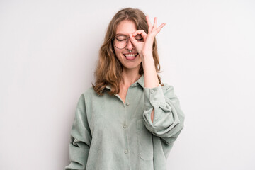 teenager young girl smiling happily with funny face, joking and looking through peephole, spying on...