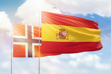 Sunny blue sky and flags of spain and norway