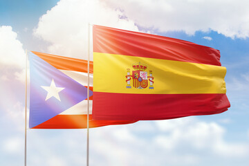 Sunny blue sky and flags of spain and puerto rico
