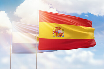 Sunny blue sky and flags of spain and argentina