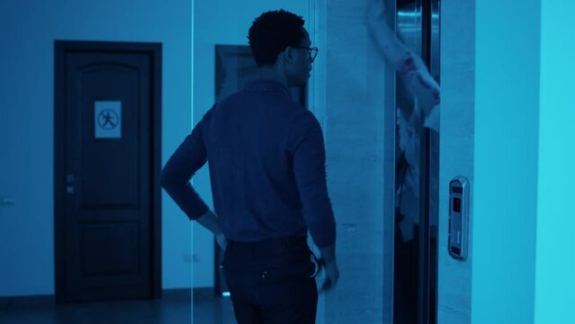 Businessman going home but starting to run when creepy brain-eating monsters came out of elevator at night.Office worker going home but horror looking bloody zombies get in his way and chase him