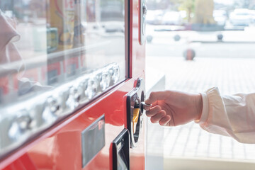 Close-up of the child who buys a drink at a Japanese vending machine. 日本の自動販売機で飲み物を買う子供のクローズアップ	
