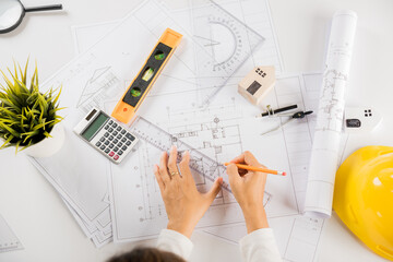 Architectural project workplace. Architect drawing with ruler on house plan blueprint paper for...