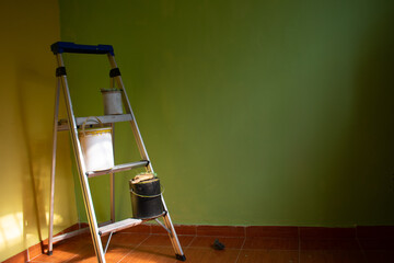 renovation of a room with copy space, paint buckets and a ladder with soft light