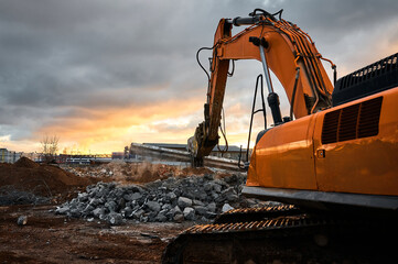 Excavator with concrete crusher on rig at demolition site