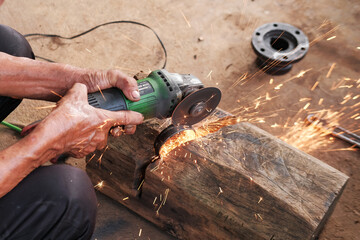Male worker cutting metal iron with angle saw with sparks.