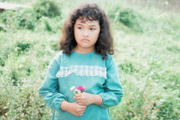 Portrait of a young Asian woman with curly hair with various facial expressions in the park in the morning