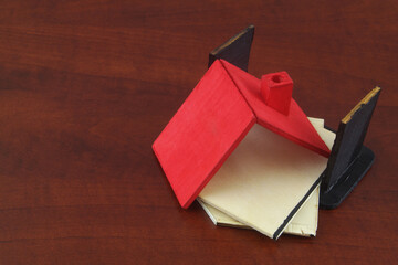 Destroyed house on wooden background. Demolition, earthquake, terrorist attack or natural disaster concept.