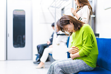 A pregnant woman feeling sick on the train