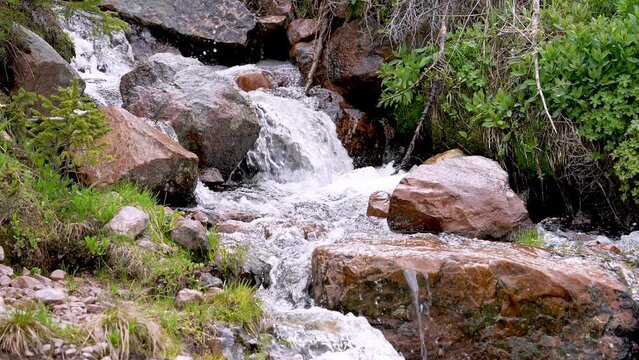 Small river cascading over the rocks in the Uinta Mountains in late Spring in Utah.