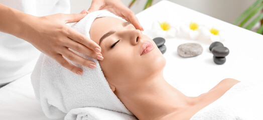 Young woman having facial massage in beauty salon