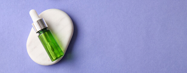 Bottle of cosmetic serum and spa stone on color background with space for text