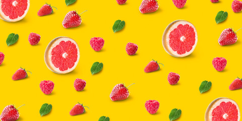 Grapefruits, berries and mint on yellow background. Pattern for design