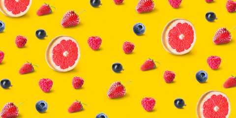 Grapefruits and berries on yellow background. Pattern for design