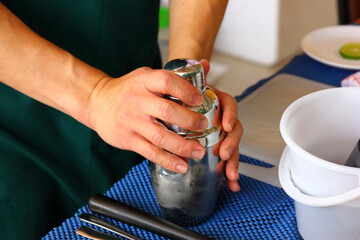 the bartender close  steel shaker after mix cocktile before shaking