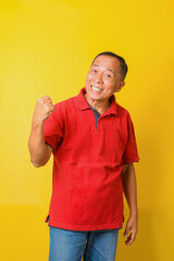 Attractive Asian senior man wearing casual shirt celebrating surprised and amazed for success with arms raised and beamed teeth. Yes, oh yeah moment. 