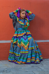 Fototapeta na wymiar Young Mexican woman prepares her dress and makeup for a traditional Mexican dance
