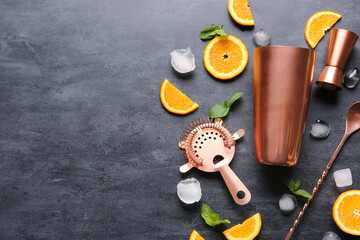 Cocktail ingredients, cobbler shaker, double jigger, strainer and mixing spoon on dark background