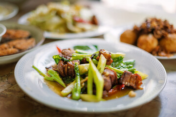 Stir fried kale vegetables with fried pork in the plate for breakfast or lunch or dinner,some menu on food table