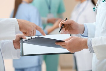 Doctors writing on clipboard in clinic