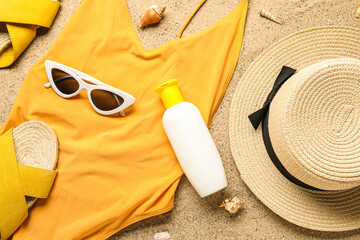 Sunscreen cream with beach accessories and seashells on sand