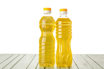 Bottles with sunflower oil on color wooden table against white background