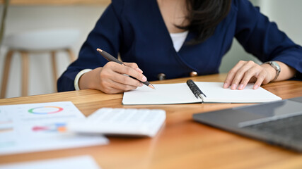Female accountant working with her accounting sales report at her office desk.