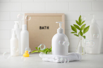 Fototapeta na wymiar Blank plastic dispenser bottles with soap and shampoo for everyday in bathroom and flying bubbles. Toiletries set