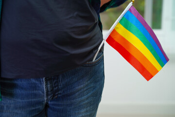 Asian woman with rainbow flag, LGBT symbol rights and gender equality, LGBT Pride Month in June.