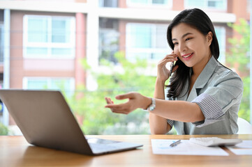 Successful asian businesswoman talking on the phone, dealing business with partner