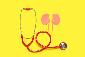 Paper kidneys with stethoscope on yellow background
