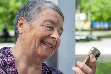 Close-up portrait of laughing Senior woman talking on mobile call, selective focus