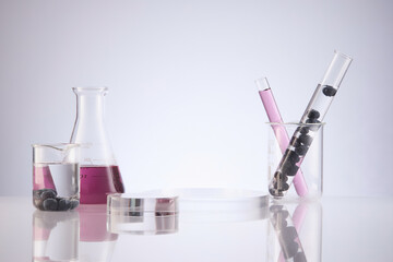 Front view of blueberry extract decorated with transparent podium and glassware blank space in white background