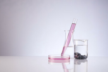 Front view of blueberry extract decorated with transparent podium and glassware blank space in white background