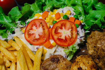 Grilled steak and lettuce, French fries on wooden plate