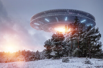 UFO, alien saucer hovering over the winter landscape in the sky. Unidentified flying object, alien invasion, extraterrestrial life, space travel, spaceship. mixed media. © Aliaksandr Marko