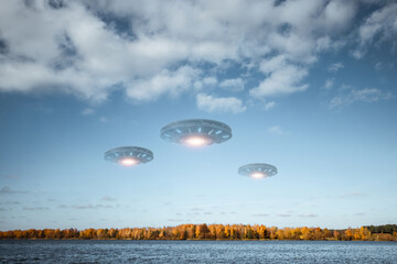 UFO, an alien saucer hovering above the lake in the clouds, hovering motionless in the sky....