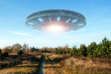 UFO, an alien saucer hovering above the field in the clouds, hovering motionless in the sky....