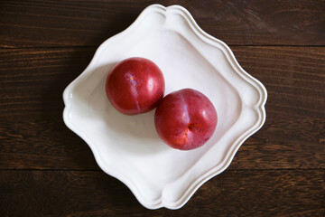 プラム、皿、木目背景、俯瞰