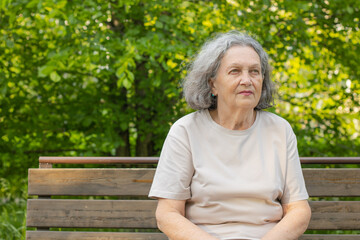 Naklejka na ściany i meble Sad elderly woman reflects on life. Wrinkles on the face, gray hair. Retirement age.