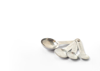 An image isolated closeup of the stainless measure spoon on the white background with copy space for text.