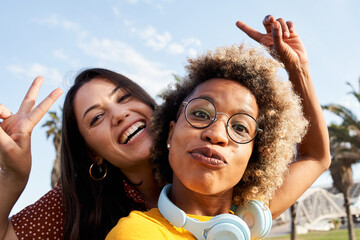 Couple of friends or girlfriends take a picture with their cell phone, playing the fool. Concept of...