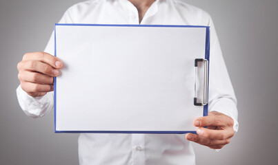 Businessman holding a blank clipboard.