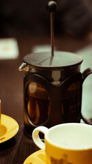 A close up picture of a French press with coffee in it 