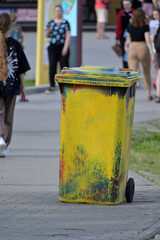 Mobile dumpster in the park alley on a summer day