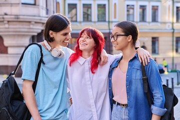 Happy smiling teenage friends hugging outdoor, on city street