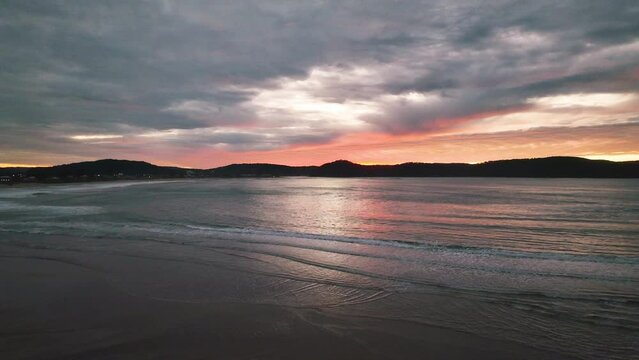 A mix of high and medium cloud put on a colourful display for sunrise at Umina Point, Umina Beach on the Central Coast, NSW, Australia.