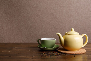 Fototapeta na wymiar Teapot with cup on wooden background. Copy space