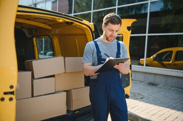 The courier brought the delivery of the box to the client. Courier service employee in uniform.