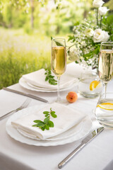 Wedding teble decoration with white flowers, glasses and white napkins. Elegantly decorated table at a wedding reception. Festive table setting. The wedding decor.
